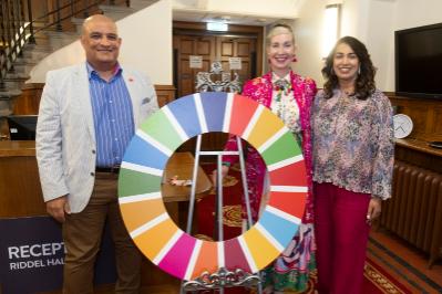 three people around the UNSDG wheel